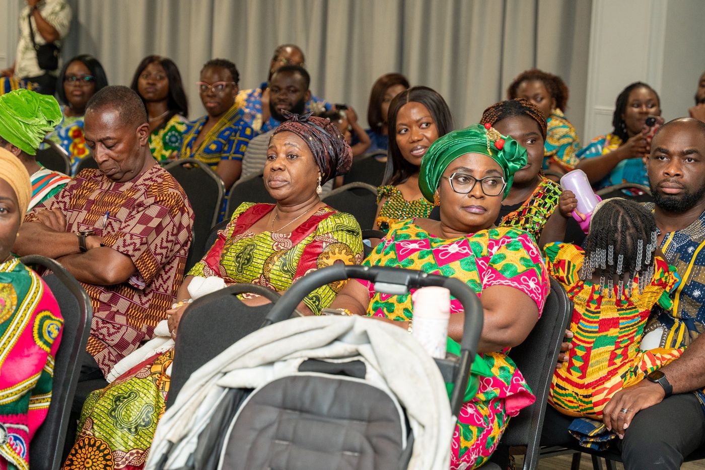 Families in kente and African print in the audience