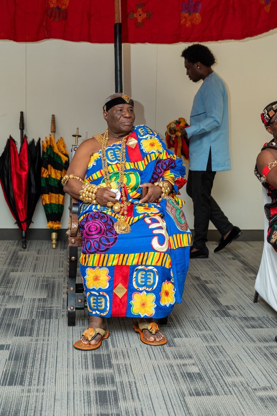 A chief seated in front of state umbrellas