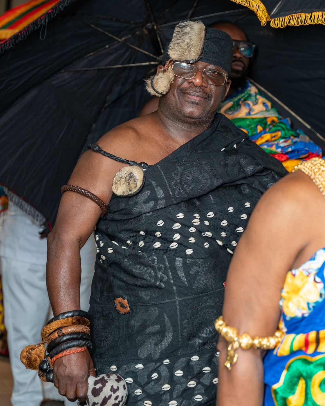A guest in black cloth decorated with cowrie shells