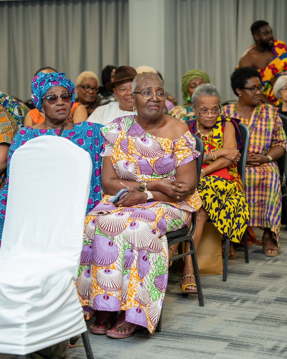 Elders in African print watching the program