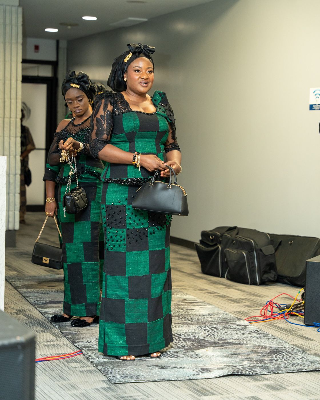 A guest in a green and black outfit arriving