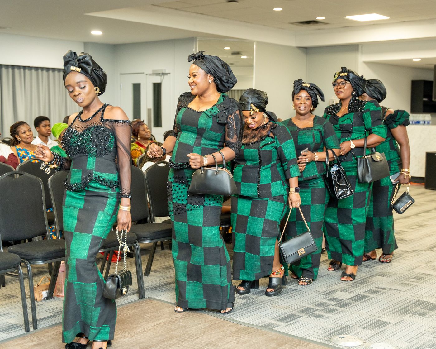 Women in matching green and black outfits making their entrance