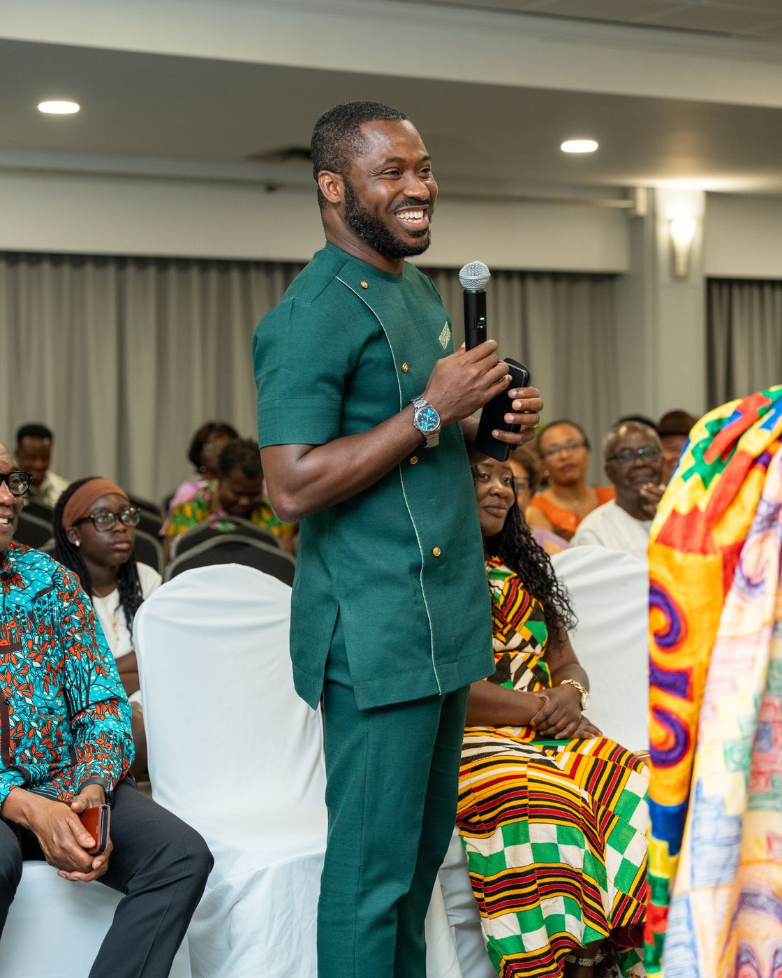 A guest in a green outfit speaking into a microphone