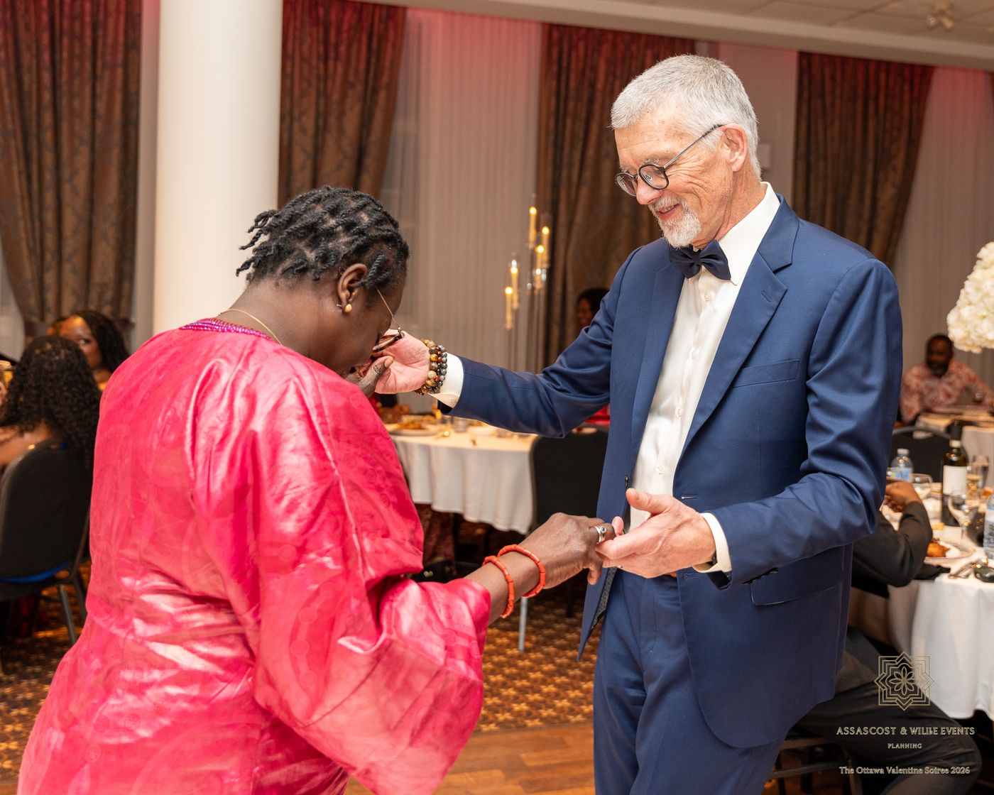 A guest in pink and a guest in a navy suit dancing together